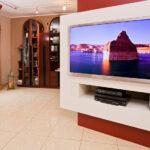 Rot und weiß lackiertes HiFi Möbel mit versteckter Kabelführung und Aufhängung für den Flat-TV.